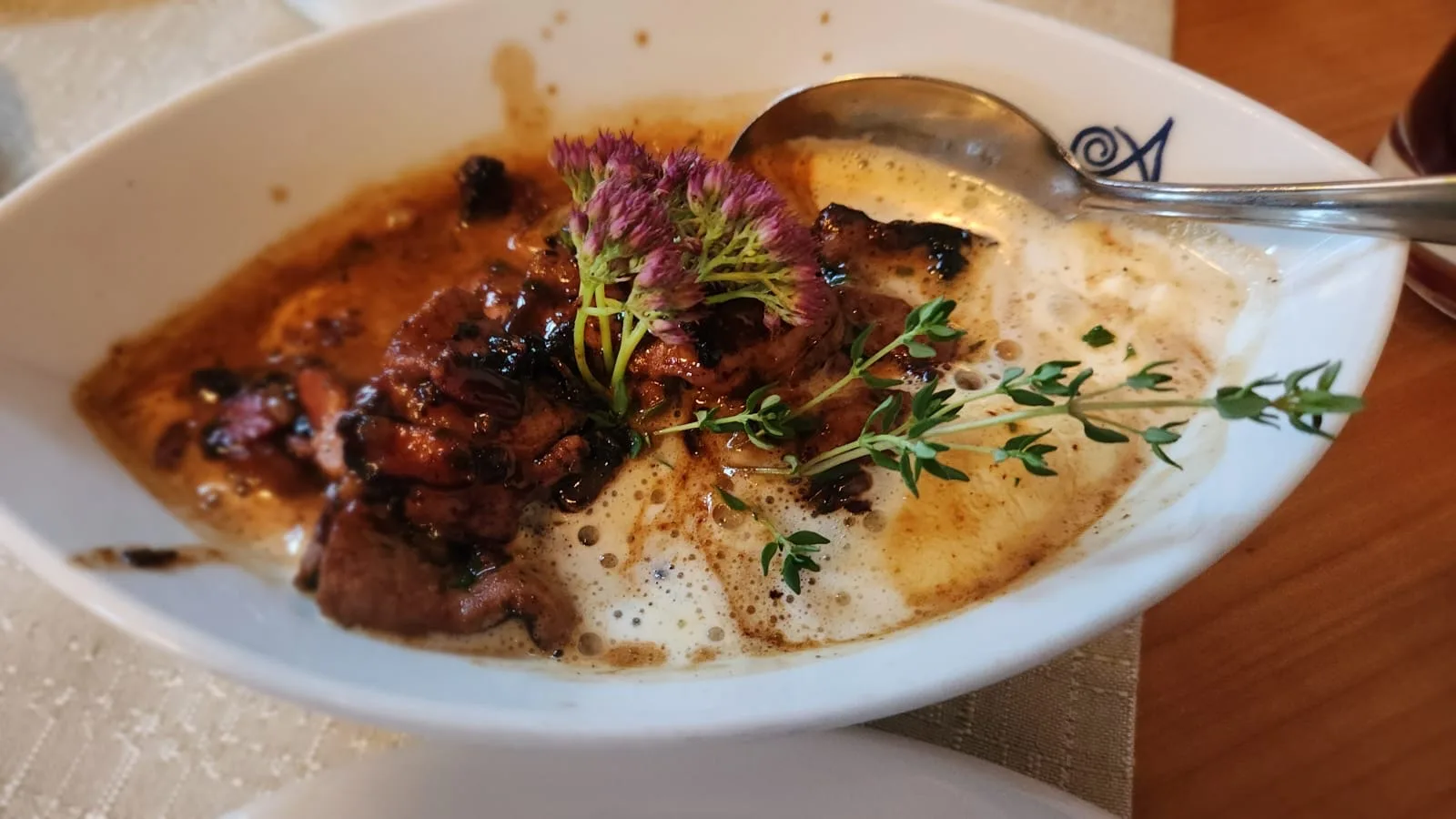 Kalbsleber in heller Rahmsauce mit Thymian in einem Schälchen mit dem Signet des Hauses