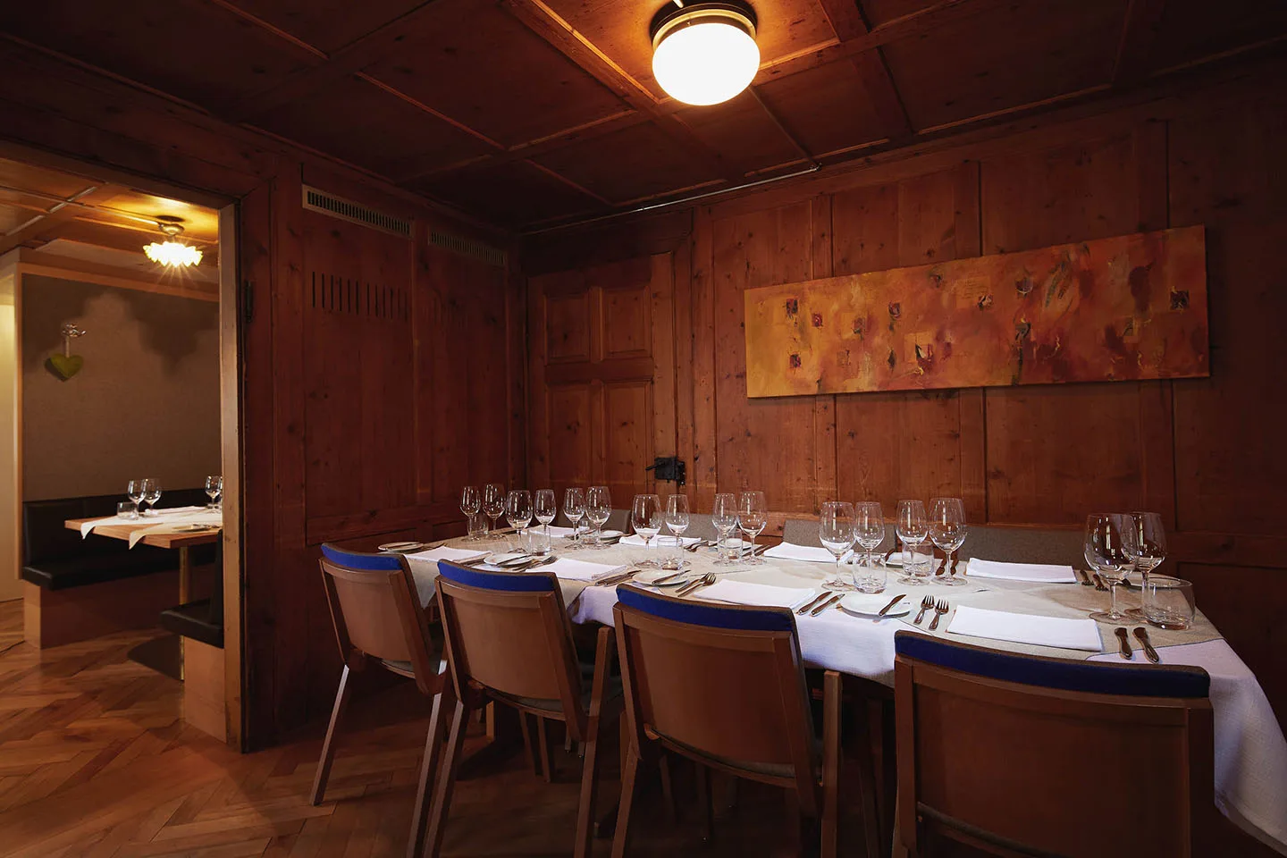Getäfelte Stube mit Kassettendecke und einer langen, gedeckten Tafel