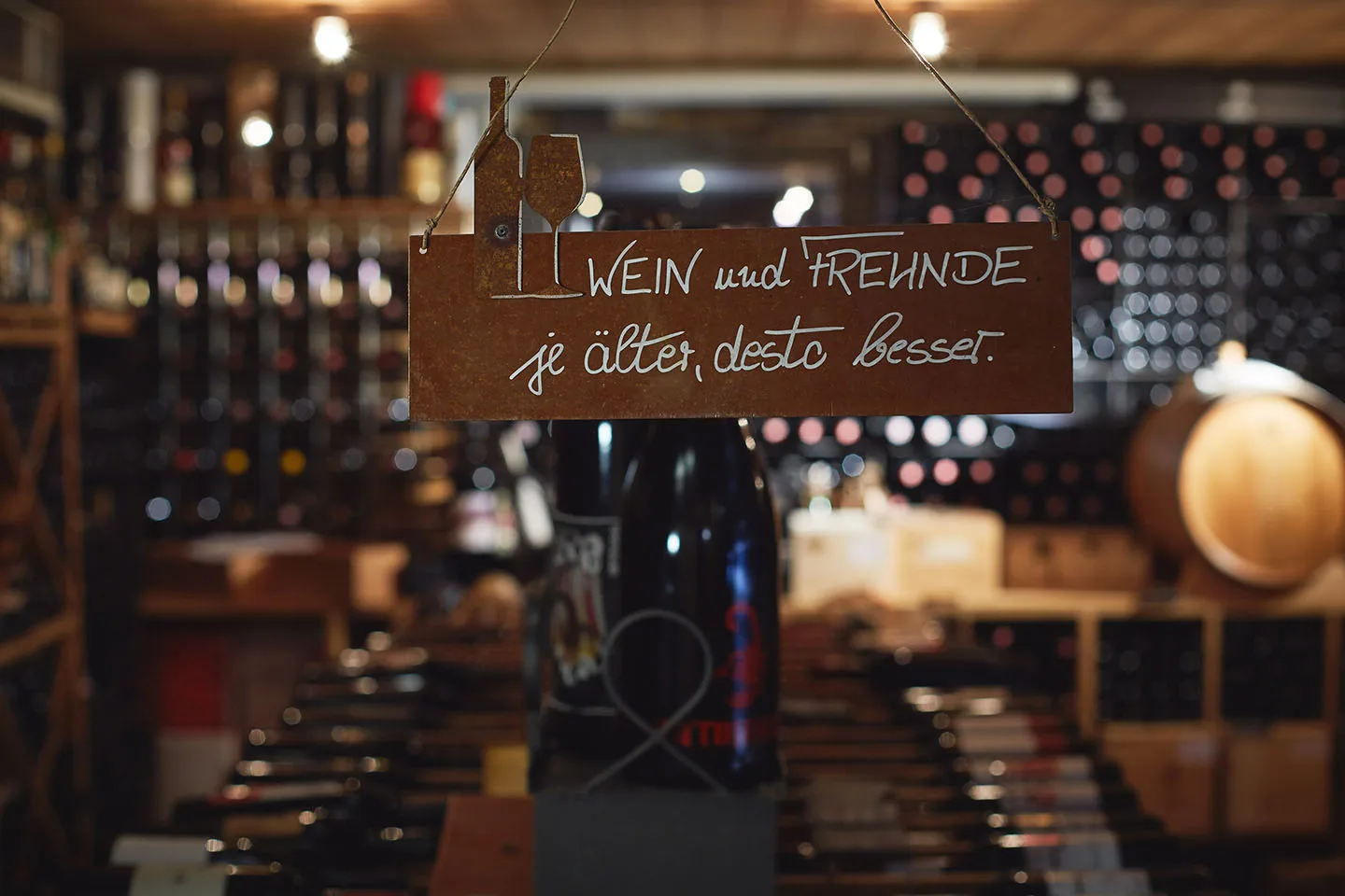 Blechschild im Weinkeller mit der Aufschrift Wein und Freunde, je älter, desto besser